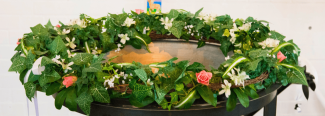 Taufbecken geschmückt mit einem Blumenkranz